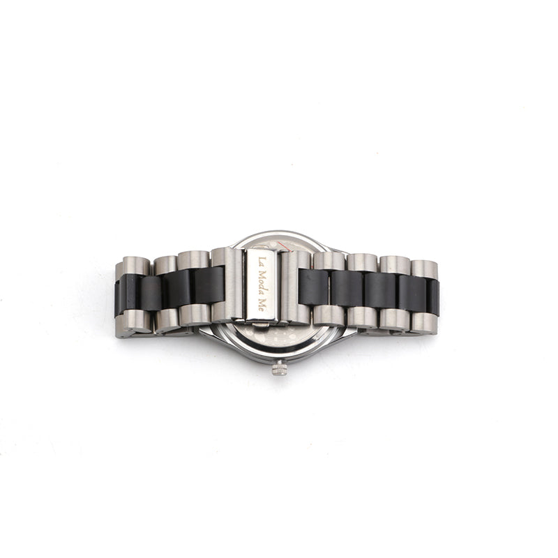 Back view of a wristwatch with a two-tone black and silver metal link strap and a clasp engraved with “La Moda Me”, displayed on a white background.